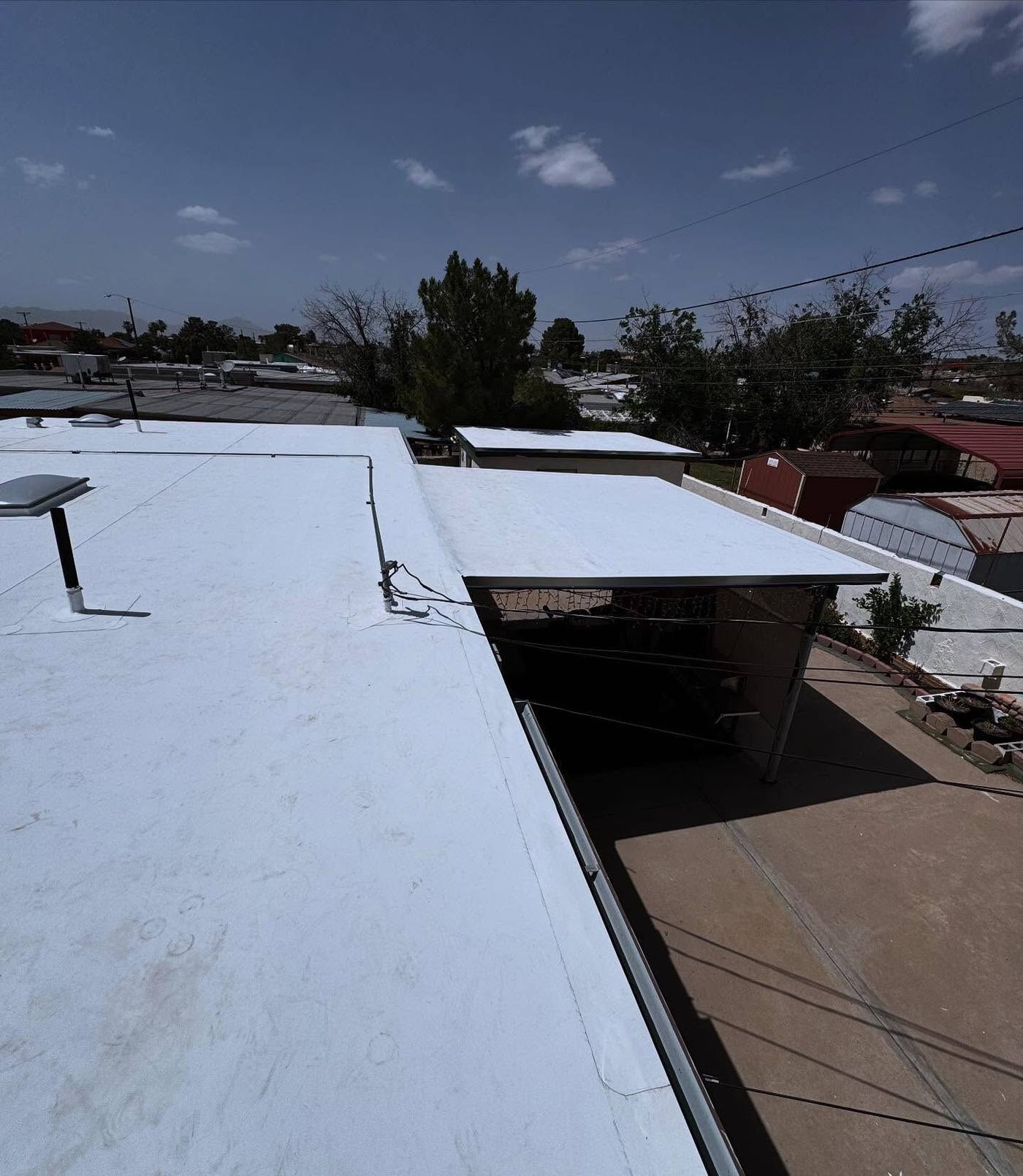 Coated low-slope roofs on adjoining buildings